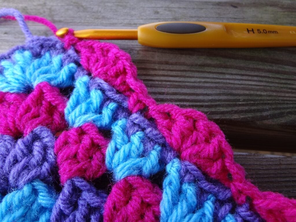 Add a pretty scallop edge to your crochet square with this simple tutorial from Fiber Flux. Great for finishing afghans or dishcloths. #crochetborder #crochetedge #freecrochettutorial #fiberflux #crochetblanket
