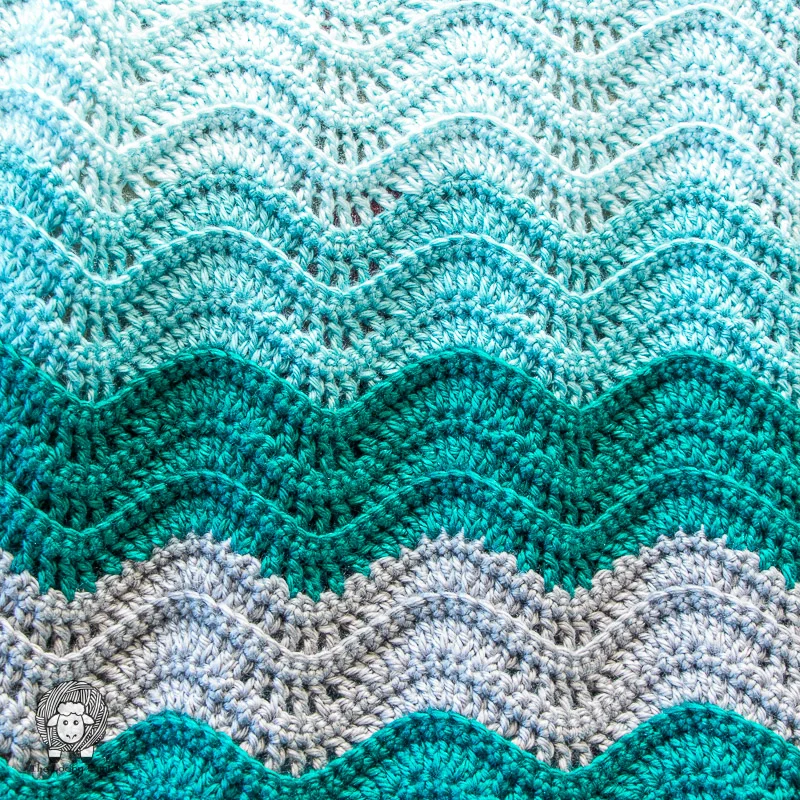 The Teal Tempest Wave Blanket Crochet Pattern combines basic stitches to create a beautiful ripple effect that mimics ocean waves. This beginner-friendly design is easy to follow and includes a helpful video tutorial. Get the free written pattern on Ashley's site, The Loopy Lamb and watch the video tutorial on YouTube here.