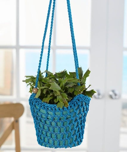 This great pattern uses Size 18 Crochet Nylon Thread and a 4 mm (G) crochet hook. The finished plant holder measures 6 inches in diameter at the base and is 6 inches high, excluding the straps. The strap measures 13 inches in length. I love the wooden beads added to the straps! Designed by Donna Wolfe.