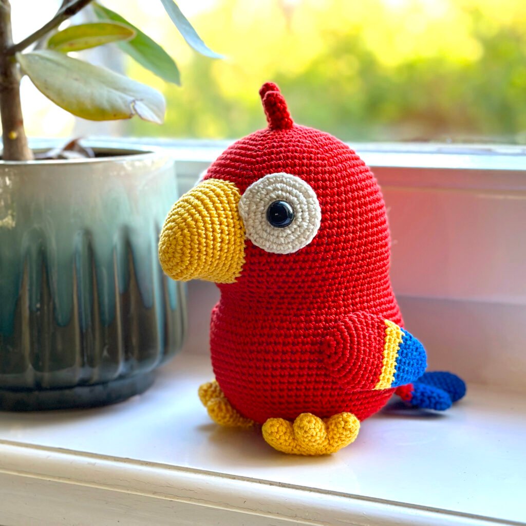Say hello to Poco the Parrot! 🦜 Get the free pattern on the DIY Fluffies blog and crochet this adorable bird.