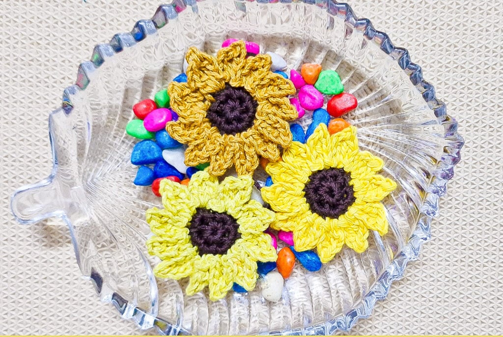 Crochet this quick and easy sunflower appliqué with the free video tutorial by Raji’s Craft Hobby. Perfect for fall décor and accessories!
