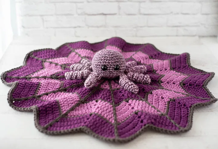 Designed by Crochet 365, Knit Too, this adorable Spider on a Web Lovey is perfect for your little one this Halloween. This easy to make project was crocheted with Aran Weight Yarn [3] and a 5 mm (H) crochet hook. When complete the lovey blanket measures 21 inches across at its widest point.