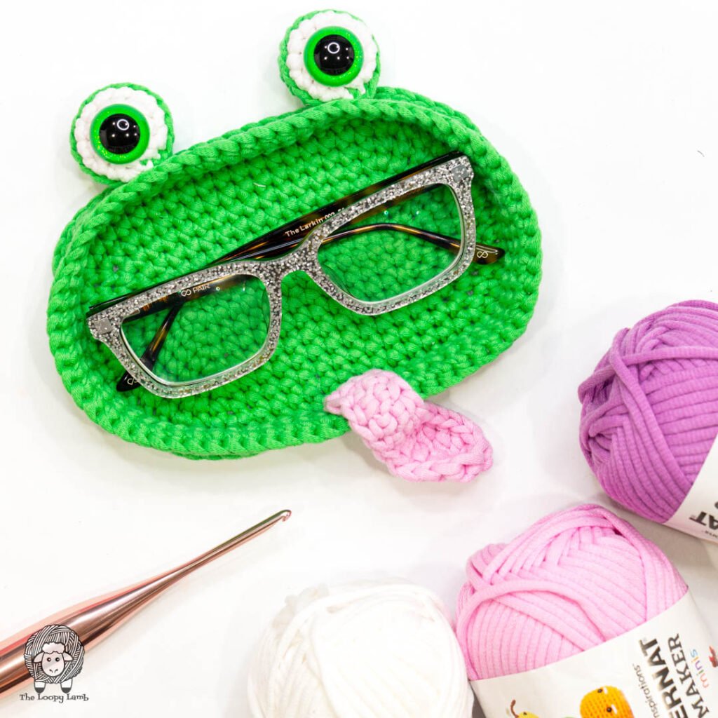 Crochet a fun frog-shaped glasses holder 🐸 Free pattern by The Loopy Lamb — quick, easy, and perfect for home or gifting.